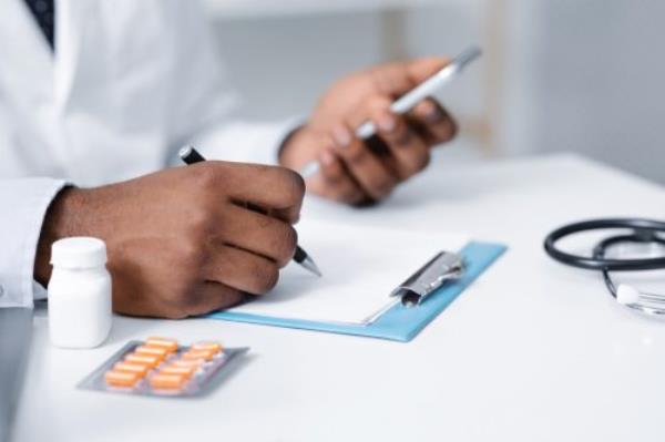 doctor making pills pres<em></em>cription online, using mobile phone, filling medical chart