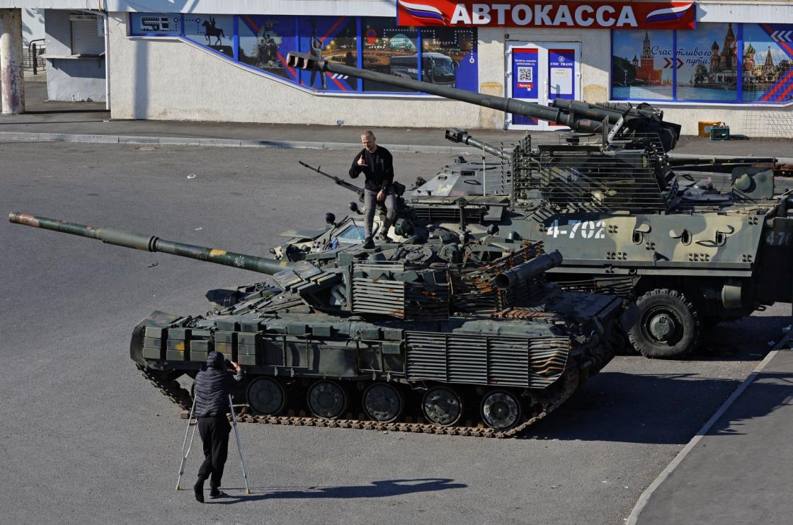 A man poses atop a tank at an exhibition of Ukrainian military equipment captured in the course of Russia-Ukraine conflict, at the station square in Luhansk, Russian-co<em></em>ntrolled Ukraine, Oct. 15, 2023. (Reuters File Photo)