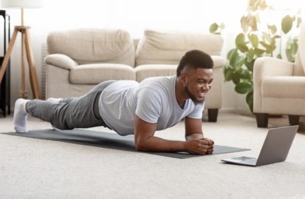 man doing an o<em></em>nline workout in his living room