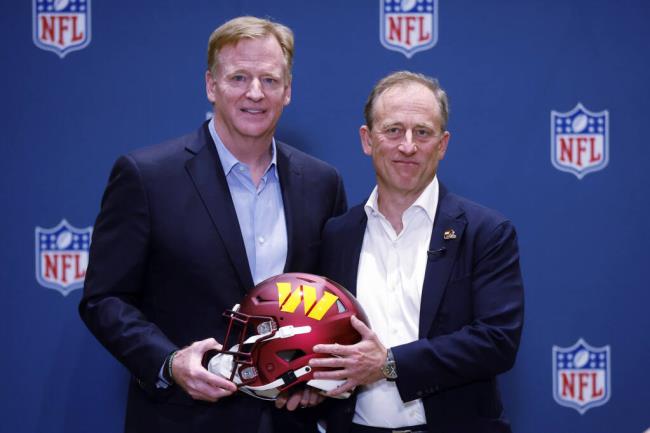 NFL Commissio<em></em>ner Roger Goodell presents new Washington Commanders owner Josh Harris with a team helmet after a special meeting to vote on approval of the sale of the team, Thursday, July 20, 2023, in Bloomington Minn. (AP Photo/Bruce Kluckhohn)