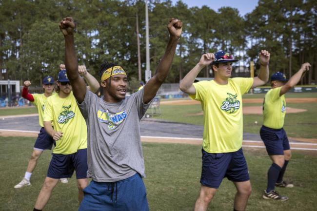 FILE - Savannah Bananas first ba<em></em>se coach Maceo Harrison, foreground, teaches a dance routine to members of the team before they play the Florence Flamingos, Tuesday, June 7, 2022, in Savannah, Ga. The Savannah Bananas, who became a natio<em></em>nal sensation with their irreverent style of ba<em></em>seball, are leaving the Coastal Plains League to focus full attention on their professio<em></em>nal barnstorming team. Owner Jesse Cole made the announcement in a YouTube video, saying “we'll be able to bring the Savannah Bananas to more people in Savannah and around the world."(AP Photo/Stephen B. Morton, File)
