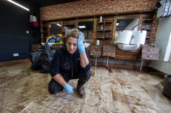  A distraught Lia Vaz cleaning up last week at The Urban Shave which had been renovated six mo<em></em>nths ago and has now been destroyed by the Storm Babet flooding in Midleton, Co Cork. Picture: Dan Linehan