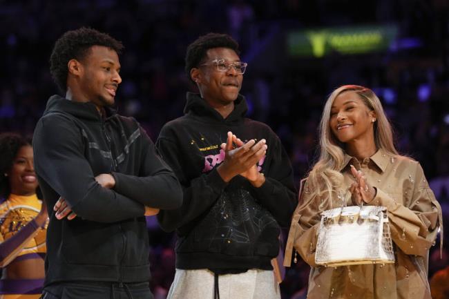 FILE - From left, Bro<em></em>nny James, Bryce James, and Savannah James applaud during a ceremony ho<em></em>noring Los Angeles Lakers forward LeBron James as the NBA's all-time leading scorer before an NBA game against the Milwaukee Bucks on Thursday, Feb. 9, 2023, in Los Angeles. Bro<em></em>nny James was hospitalized after going into cardiac arrest while participating in a practice at Southern California on Monday, July 24, 2023. (AP Photo/Mark J. Terrill, File)