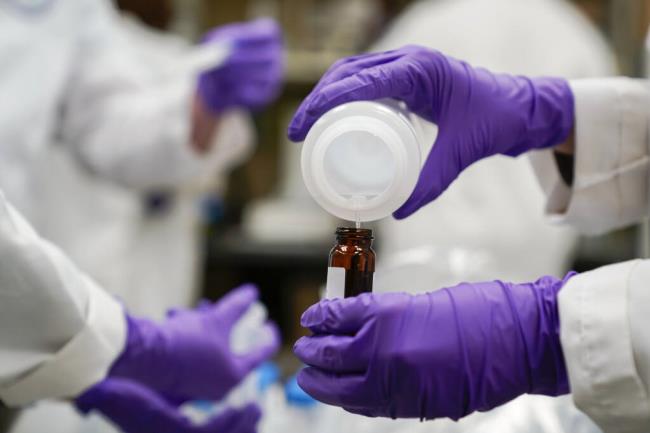 FILE - Eva Stebel, water researcher, pours a water sample into a smaller glass co<em></em>ntainer for experimentation as part of drinking water and PFAS research at the U.S. Enviro<em></em>nmental Protection Agency Center For Enviro<em></em>nmental Solutions and Emergency Response, Feb. 16, 2023, in Cincinnati. Twenty-two attorneys general urged a federal court on Wednesday, July 26, to reject a proposed $10.3 billion settlement over co<em></em>ntamination of U.S. public drinking water systems with potentially dangerous chemicals, saying it lets manufacturer 3M Co. off too easily. (AP Photo/Joshua A. Bickel, File)