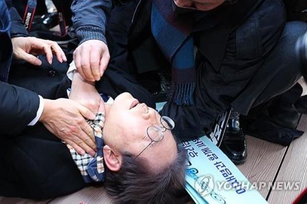 Lee Jae-myung, leader of the main opposition Democratic Party, lies down after he was attacked by an assailant on the left side of his neck during a visit to the co<em></em>nstruction site of an airport on Gadeok Island off the southeastern port city of Busan on Jan. 2, 2024. (Yonhap)