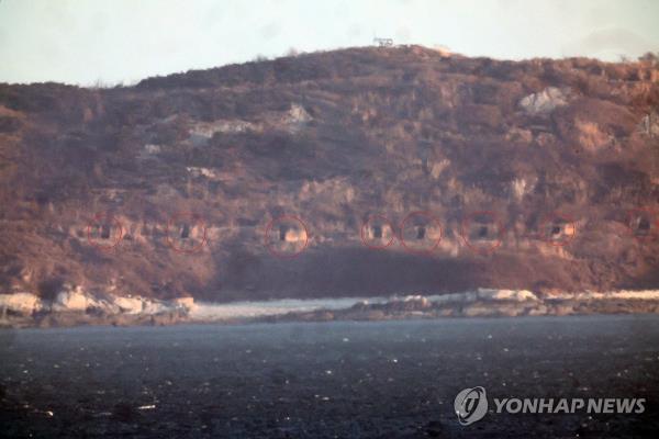 The gun ports of the coastal artillery on a North Korean island near the Northern Limit Line, a de facto maritime border, remain open in this photo taken from South Korea's front-line island of Yeo<em></em>npyeong on Jan. 7, 2023. (Yonhap)