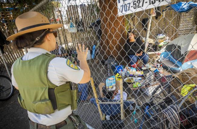 So<em></em>noma County Park Ranger Ilana Stoelting hands out “Notice to Vacate” warnings to the homeless in encampments along the Joe Rodota trail in Santa Rosa July 22, 2022. (Photo by John Burgess)