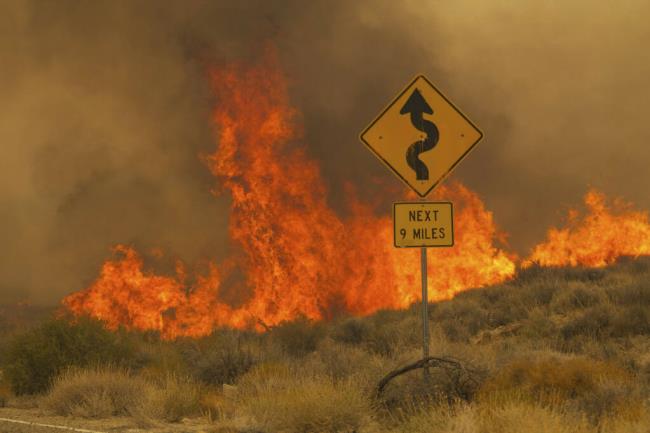 Flames rise from the York Fire on Ivanpah Rd. on Sunday, July 30, 2023, in the Mojave Natio<em></em>nal Preserve, Calif. The York Fire has burned over 77,000 acres and has 0% containment. (AP Photo/Ty ONeil)