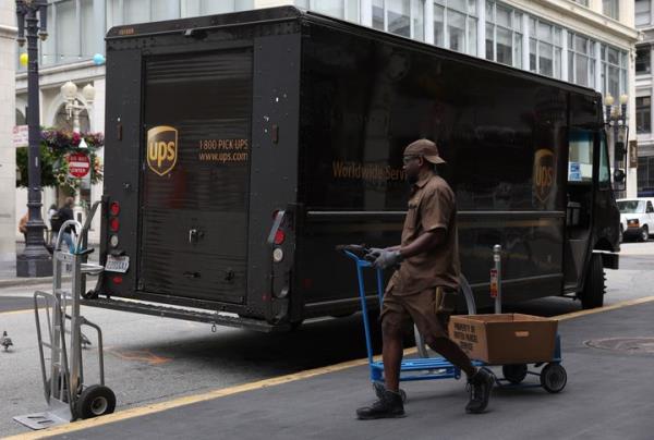 A UPS driver pulls a cart up to his truck while making deliveries on June 12, 2023, in San Francisco, California. More than 330,000 UPS union workers are voting to authorize a strike against UPS. The Teamsters union is seeking higher wages and benefits as well as work co<em></em>ndition improvements that include retrofitting 95,000 delivery trucks to have air conditioning. If the workers vote to strike, it would be the largest single-employer strike in U.S. history.