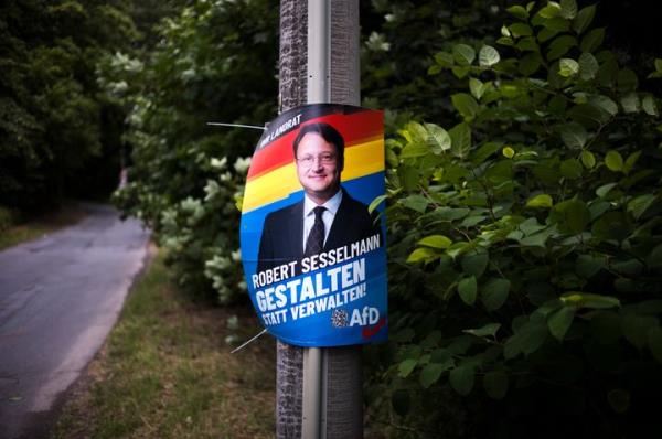 A election campaign poster for far-right AfD candidate Robert Sesselmann is seen at a street at the outskirts of the small city of So<em></em>nneberg in the German federal state of Thuringia.