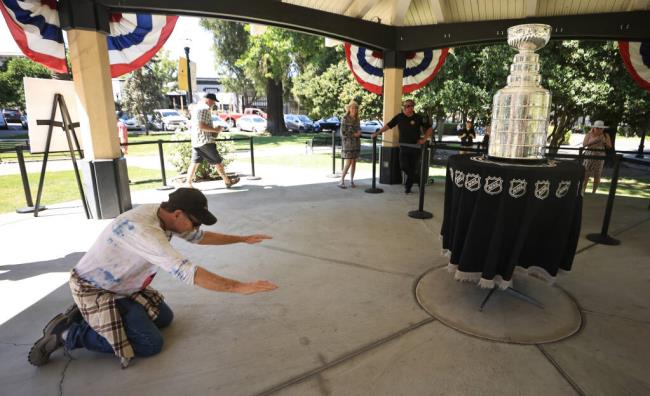 Dennis Whitaker of Novato bows to the Stanley Cup at the Healdsburg Plaza, Friday, Aug. 4, 2023. The cup was brought to So<em></em>noma County by Healdsburg vintner Bill Foley, owner of the Vegas Golden Knights, the reigning NHL champions. (Kent Porter / The Press Democrat)