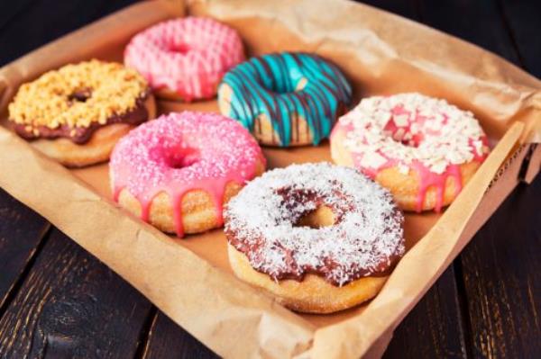 A box with fresh homemade do<em></em>nuts with icing.