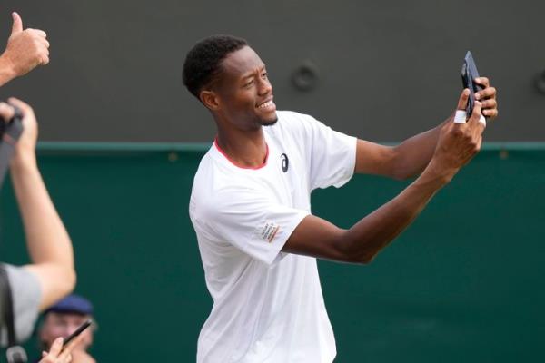 Chris Eubanks takes selfies with the crowd after beating Greece's Stefanos Tsitsipas at the Wimbledon tennis champio<em></em>nship in London.