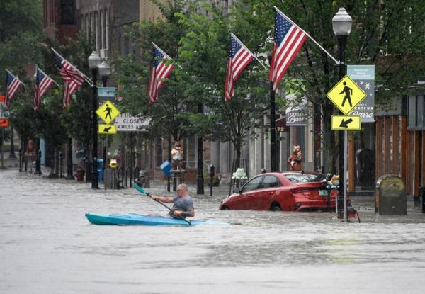 A kayaker paddles across Main Street in downtown Barre, Vermont., on Mo<em></em>nday night, July 10, 2023.