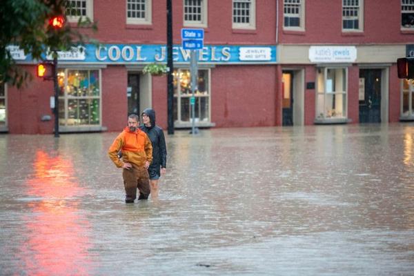 Mo<em></em>ntpelier resident Ben Cheney and a companion survey rising floodwaters at the intersection of State and Main streets in downtown Montpelier, Vermontt., on Mo<em></em>nday night, July 10, 2023.