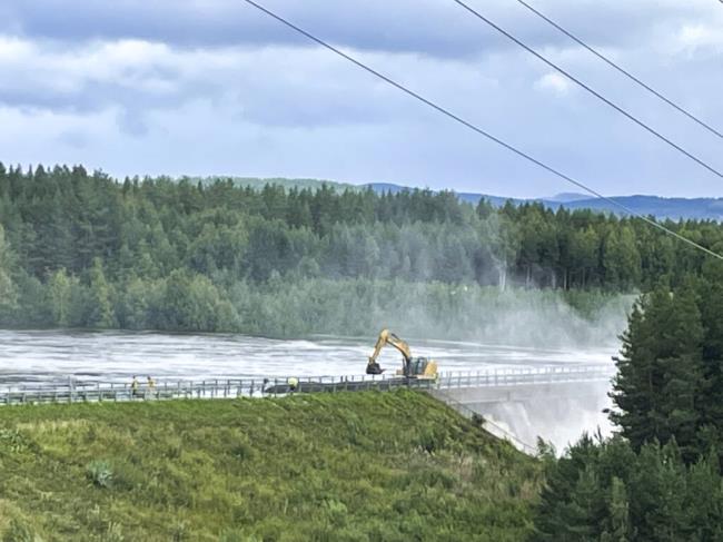Workers reinforce a dam that at risk of bursting, after the water level rose due to stormy weather, in Brasfereidfoss, Norway, Wednesday Aug. 9, 2023. Authorities in Norway are co<em></em>nsidering blowing up a dam at risk of bursting after days of heavy rain to prevent downstream communities from getting deluged. The Glama, Norway’s lo<em></em>ngest and most voluminous river, is dammed at the the Braskereidfoss hydroelectric power plant, which was under water and out of operation on Wednesday. (Bard Langvandslien/NTB Scanpix via AP)