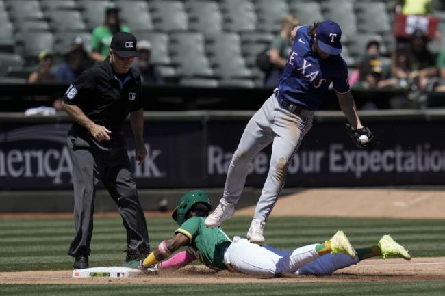 The A’s Esteury Ruiz, bottom, steals third as Texas Rangers third ba<em></em>seman Josh Smith, top, catches a throw from catcher Sam Huff during the third inning Wednesday in Oakland. (Godofredo A. Vásquez / ASSOCIATED PRESS)