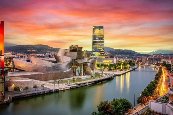 The cityscape of Bilbao at sunset. The Nervion river crosses Bilbao downtown, hosting in its margins the traditio<em></em>nal and modern buildings of the city with the  Guggenheim Museum and Iberdrola tower.