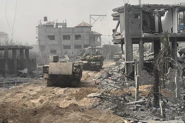 In this undated photo provided by the Israeli military, Israeli armored perso<em></em>nnel carriers move past destroyed buildings during a ground operation in the Gaza Strip. 