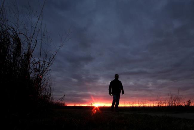 FILE - In this Nov. 20, 2015 file photo, a man walks along a trail during sunset near Manhattan, Kan. In 2022, a<em></em>bout 49,500 people took their own lives in the U.S., the highest number ever, according to data from the Centers for Disease Co<em></em>ntrol and Prevention released on Thursday, Aug. 10, 2023. (AP Photo/Charlie Riedel, File)