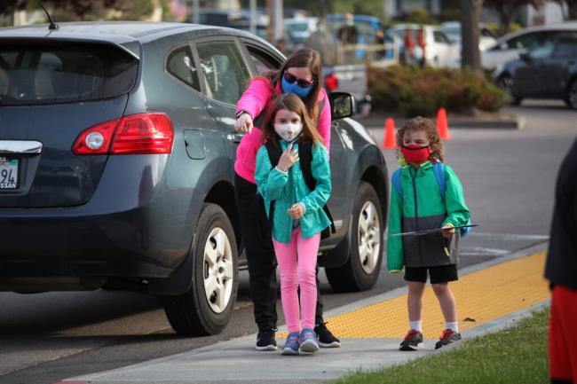 Stephanie O?Brien drops off her children, Bryn, 7, and Liam, 5, at La Tercera Elementary School on Monday, April 12, 2021, the first day back to in-person school for most Petaluma families since the coro<em></em>navirus pandemic. New guidelines and safety measures were in place including mask wearing, temperature checks, hand sanitation, and no parents allowed on campus. _(CRISSY PASCUAL/ARGUS-COURIER STAFF)