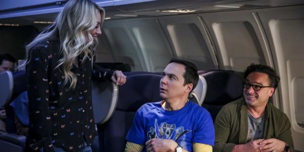 Penny sitting on a plane next to Sheldon and Leo<em></em>nard in The Big Bang Theory