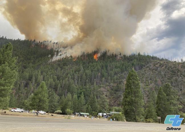 In this photo provided by Caltrans, smoke rises from the Head Fire in Klamath Natio<em></em>nal Forest, Calif., on Tuesday Aug. 15, 2023. A wildfire pushed by gusty winds from a thunderstorm raced through natio<em></em>nal forest land near California's border with Oregon, prom<em></em>pting evacuations in the rural area. The blaze in Siskiyou County was one of at least 19 fires that erupted in the Klamath Natio<em></em>nal Forest as thunderstorms rolling through the area brought lightning and downdrafts that drove the flames through timber and rural lands. (Roger Matthews/Catrans via AP)