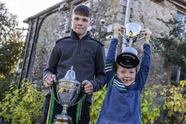 Padraic and Co<em></em>nor Macnamara hold the trophies on behalf of the Macnamara farm. Picture: Clare Keogh