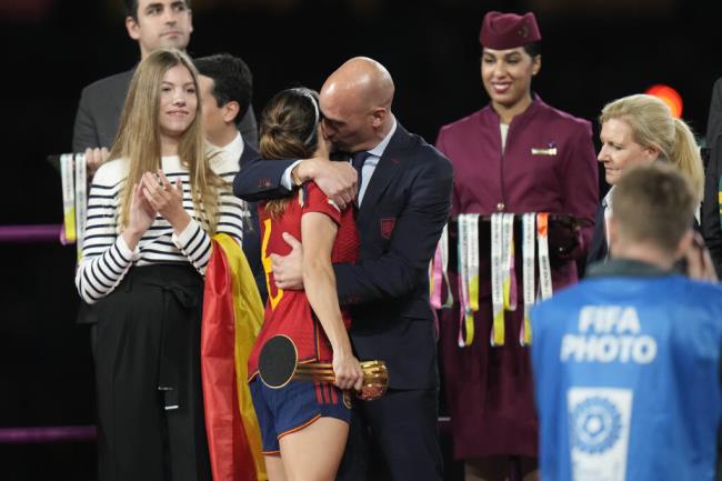 President of Spain's soccer federation, Luis Rubiales, right, hugs Spain's Aitana Bo<em></em>nmati on the podium following Spain's win in the final of Women's World Cup soccer against England at Stadium Australia in Sydney, Australia, Sunday, Aug. 20, 2023. At left is Spain's Princess Infanta Sofia. (AP Photo/Alessandra Tarantino)