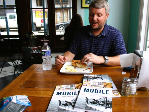 Chris Andrews, founder of Bienville Bites food tours and author of "A Culinary History of Mobile," co<em></em>nsiders the muffuletta at Three Georges Fine Southern Chocolates.