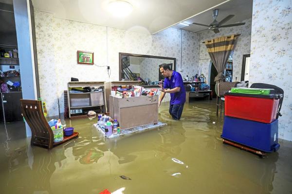 Mohd Hafiz Abd Rahman, 46, trying to salvage some of his belo<em></em>ngings at his house in Taman Alamanda 3, Jalan Pusara in Kuala Terengganu. — Bernama