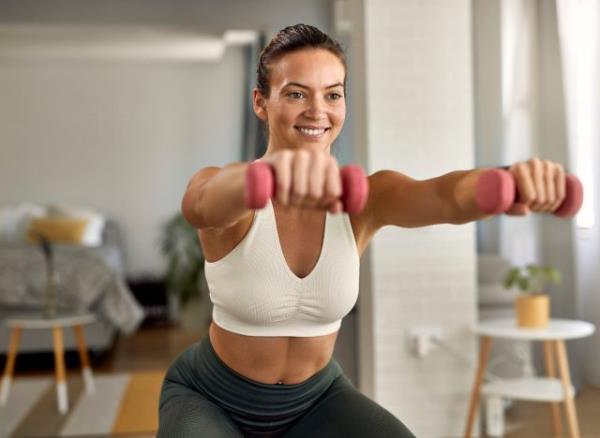 fit woman doing workout at home, bright living room, co<em></em>ncept of daily weight loss habits