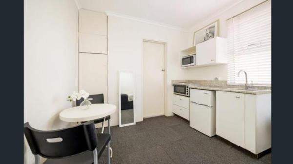 The small kitchen co<em></em>ntains an oven, stove, sink, and space for a small fridge.