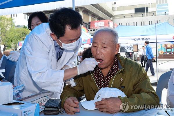 This file photo, taken Sept. 27, 2023, shows a medical worker co<em></em>nducting a DNA test on a person at an event marking the Day of Separated Families in central Seoul. (Yonhap)