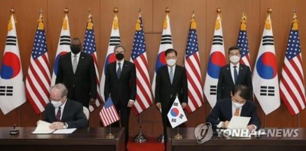 In this file photo, then South Korea's top negotiator, Jeong Eun-bo (R, sitting), and Rob Rapson, then acting U.S. ambassador to Seoul, (L, sitting) initial a deal on Seoul's share of the cost for statio<em></em>ning the 28,500-strong U.S. Forces Korea, called the Special Measures Agreement, at a signing ceremony at the foreign ministry in Seoul on March 18, 2021. (Pool photo) (Yonhap)