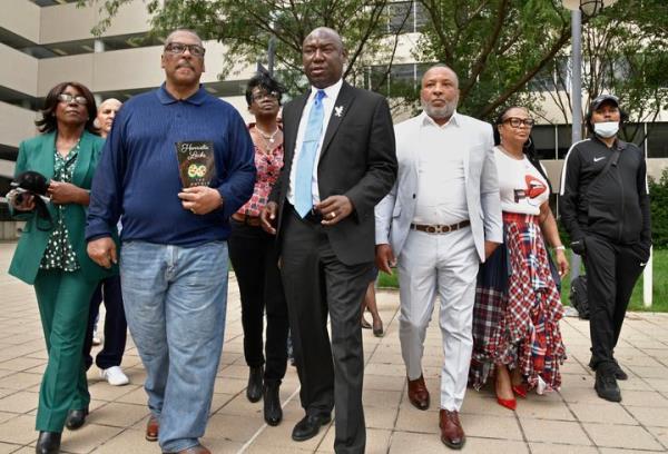 Attorney Ben Crump, middle, surrounded by four grandchildren of Henrietta Lacks and two spouses, head to an October 2021 news co<em></em>nference outside the Edward A. Garmatz U. S. District Courthouse to announce the filing of a lawsuit against Thermo Fisher Scientific, Inc., a multibillion-dollar biotechnology corporation, on behalf of the estate of Henrietta Lacks in Baltimore. From left, Hope and Ron Lacks, Kimberley Lacks, Crump, Alfred Lacks Carter with his wife, Jewel Carter, and Jason O'Neal.