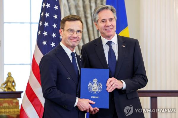 U.S. Secretary of State Antony Bl<em></em>inken (R) accepts Sweden's instruments of accession from Swedish Prime Minister Ulf Kristersson for its entry into NATO at the State Department in Washington on March 7, 2024 in this photo released by Reuters. (Yonhap)