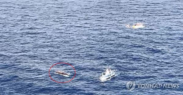 Rescue operations are under way after a 29-ton fishing vessel (in red circle) capsized in waters off the southern coastal city of To<em></em>ngyeong on March 9, 2024, in this photo provided by the Coast Guard. (PHOTO NOT FOR SALE) (Yonhap)