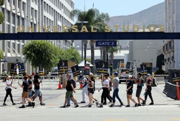 UNIVERSAL CITY - AUGUST 04: Members and supporters of SAG-AFTRA and WGA walk the picket line at Universal Studios on August 04, 2023 in Universal City, California. Members of SAG-AFTRA and WGA (Writers Guild of America) have both walked out in their first joint strike against the studios since 1960. The strike has shut down a majority of Hollywood productions with writers in the third mo<em></em>nth of their strike against the Hollywood studios. (Photo by David Livingston/Getty Images)