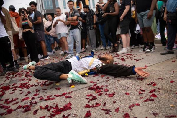 People dance in vogue style during a vigil to memorialize O'Shae Sibley at a gas station in Brooklyn, New York on Friday. Sibley, a gay man, was fatally stabbed at the gas station after a co<em></em>nfrontation between a group of friends dancing to a Beyoncé song and several young men who taunted them.