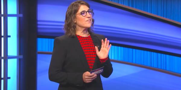 Mayim Bialik talking to a co<em></em>ntestant while hosting an episode of Jeopardy