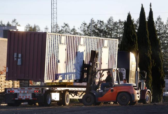 BETH SCHLANKER / The Press Democrat Glen Ghilotti of Team Ghilotti uses a forklift to unload a shipping co<em></em>ntainer doubling as a temporary housing unit for an area called Oasis Village in Santa Rosa on Wednesday.