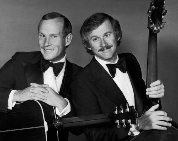 1976<em></em>:<em></em> <em></em> Studio<em></em> portrait<em></em> of<em></em> American<em></em> comedy<em></em> duo,<em></em> the<em></em> Smothers<em></em> Brothers<em></em> <em></em>(Tom<em></em> <em></em>(L<em></em>)<em></em> and<em></em> Dick<em></em> Smothers,<em></em>)<em></em> wearing<em></em> tuxedos<em></em> and<em></em> holding<em></em> guitars.<em></em> <em></em> <em></em>(Photo<em></em> by<em></em> Hulton<em></em> Archive<em></em>/Getty<em></em> Images<em></em>)