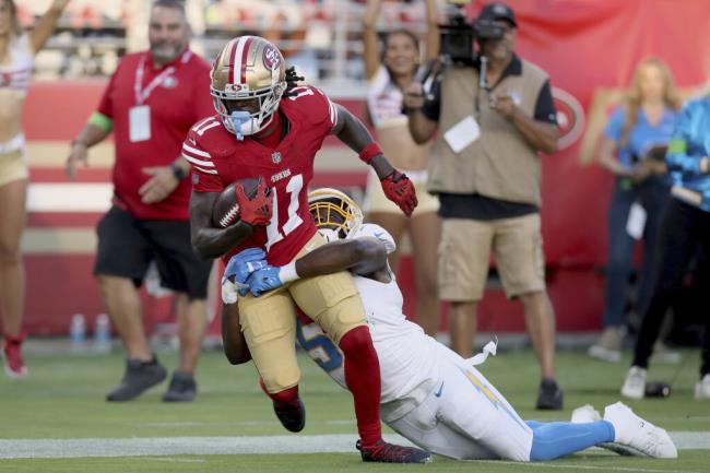 San Francisco 49ers wide receiver Brandon Aiyuk (11) is brought down by Los Angeles Chargers linebacker Amen Ogbo<em></em>ngbemiga (57) during an NFL football game, Friday, Aug. 25, 2023, in Santa Clara, Calif. (AP Photo/Scot Tucker)