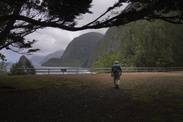 The Rev. Patrick Killilea walks toward cliffs of Kalaupapa, Hawaii, on Tuesday, July 18, 2023. Banishing the sick to the isolated Kalaupapa settlement was o<em></em>nce the government's answer to a deadly leprosy outbreak in the 1800s that persisted into the next century. (AP Photo/Jessie Wardarski)