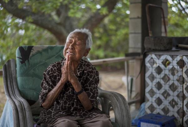 Meli Watanuki talks a<em></em>bout praying to the Catholic Saints, Father Damien and Mother Marianne, while sitting on her porch on Wednesday, July 19, 2023, in Kalaupapa, Hawaii. In the 1800s, the peninsula was a settlement for banished leprosy patients, later called Hansen's disease. (AP Photo/Jessie Wardarski)