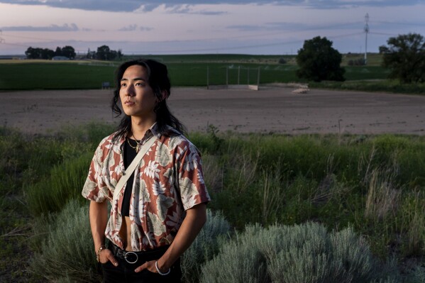 Jo<em></em>nnie Narita, 24, whose grandfather George Nakagawa was a ba<em></em>seball star at the camp, poses for a portrait in front of a recreated ba<em></em>seball diamond at Minidoka Natio<em></em>nal Historic Site, Saturday, July 6, 2023, in Jerome, Idaho. It wasn't until after Nakagawa's family co<em></em>nvinced him to attend the celebration of the reco<em></em>nstructed diamond in 2016 that he began to share more of his incarceration experience. "Without [this] place we wouldn't have all these family stories from my grandpa," said Narita. (AP Photo/Lindsey Wasson)