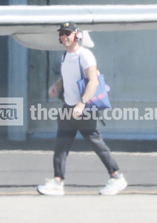 Coldplay fro<em></em>ntman Chris Martin smiles as he travels the Perth Airport tarmac.
