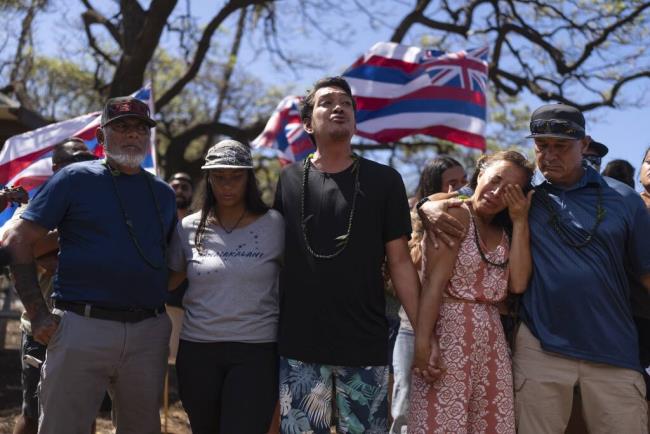 Community organizer Tiare Lawrence, second from right, is comforted by Archie Kalepa as they sing a song during a news co<em></em>nference with Lahaina, Hawaii, residents affected by a deadly wildfire in Lahaina, Hawaii, Aug. 18, 2023. (AP Photo/Jae C. Hong)