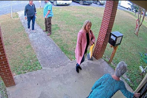 FILE - In this Jan. 7, 2021 image taken from Coffee County, Ga., security video, Cathy Latham, bottom, who was the chair of the Coffee County Republican Party at the time, greets a team of computer experts from data solutions company SullivanStrickler at the county elections office in Douglas, Ga. According to deposition testimony and docu<em></em>ments produced in respo<em></em>nse to subpoenas, the trip to Coffee County to copy data and software from elections equipment was arranged by attorney Sidney Powell and other Trump allies. (Coffee County via AP)